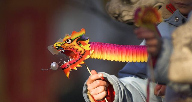 在伦敦庆祝中国新年的小朋友手中拿着纸龙